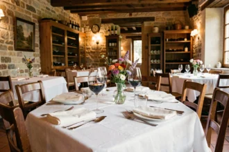 Table élégamment dressée dans un restaurant traditionnel de Bourgogne-Franche-Comté avec vin rouge et décor en pierre