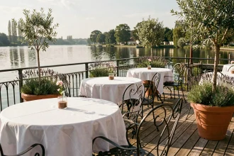 Terrasse de restaurant au bord du lac de Bordeaux avec tables en nappe blanche et vue panoramique sur l'eau